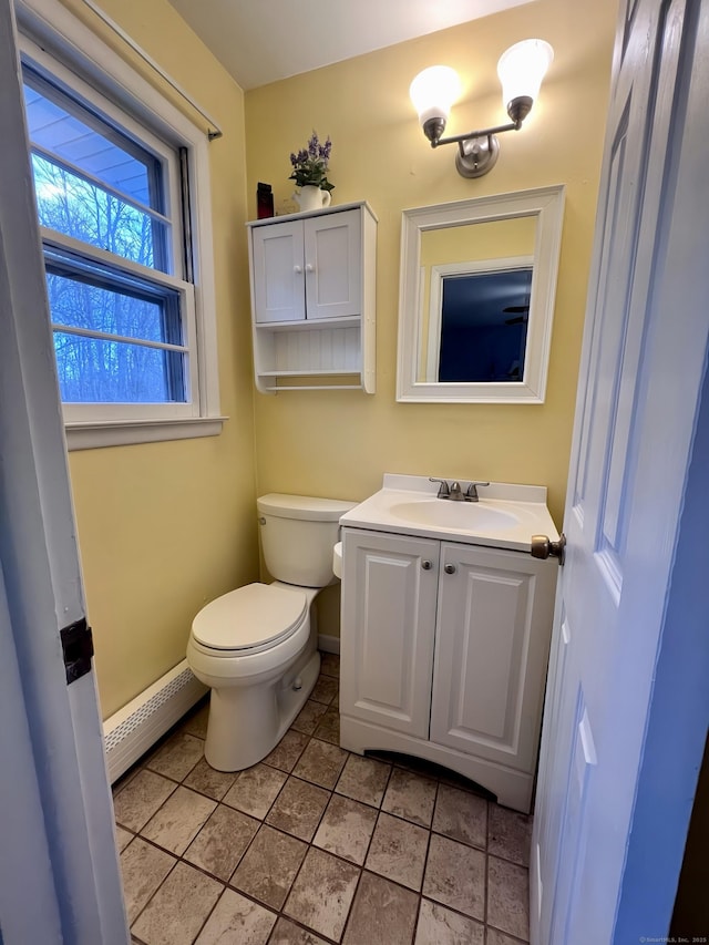 bathroom featuring vanity, a baseboard heating unit, tile patterned flooring, and toilet