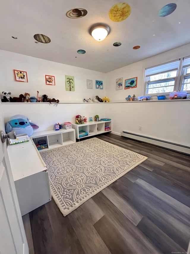 recreation room with a baseboard radiator and dark wood-type flooring