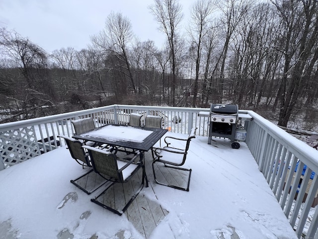 snow covered deck with a grill