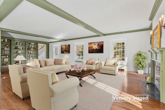 living room with ornamental molding, wood finished floors, beamed ceiling, stairs, and a fireplace