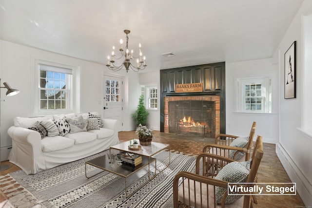 living room featuring a wealth of natural light, a brick fireplace, visible vents, and wood finished floors