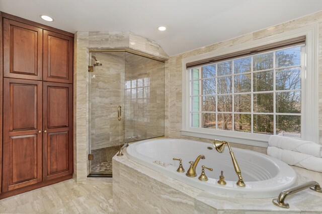 bathroom featuring a stall shower, plenty of natural light, vaulted ceiling, and a bath