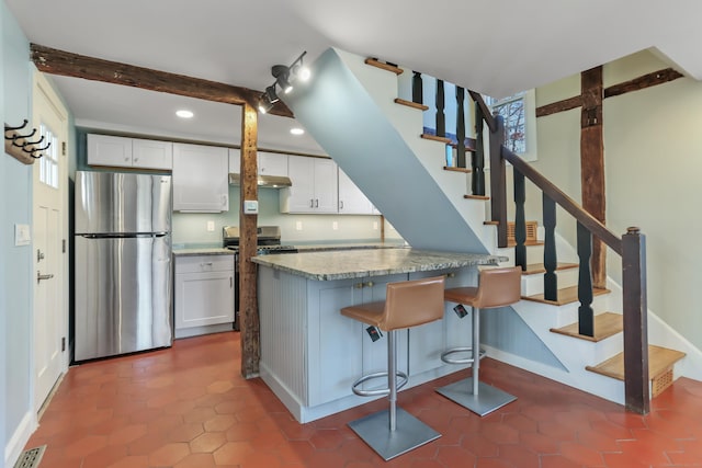 kitchen with a breakfast bar, visible vents, white cabinets, appliances with stainless steel finishes, and beamed ceiling