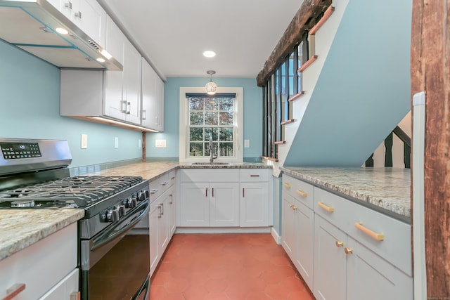 kitchen with under cabinet range hood, stainless steel gas range oven, white cabinetry, and a sink