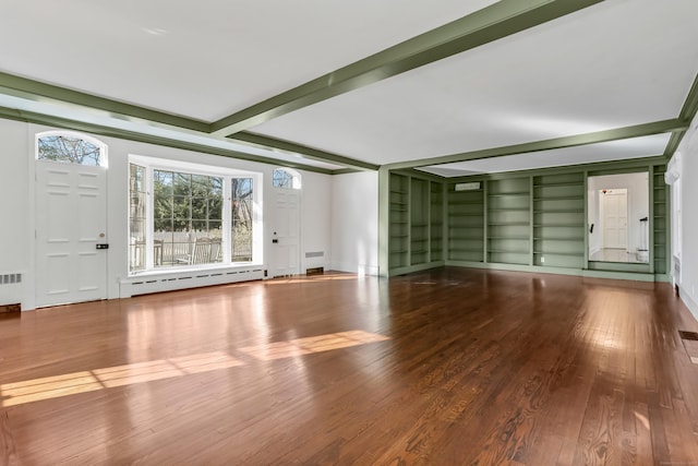 unfurnished living room featuring beam ceiling, baseboard heating, and wood finished floors