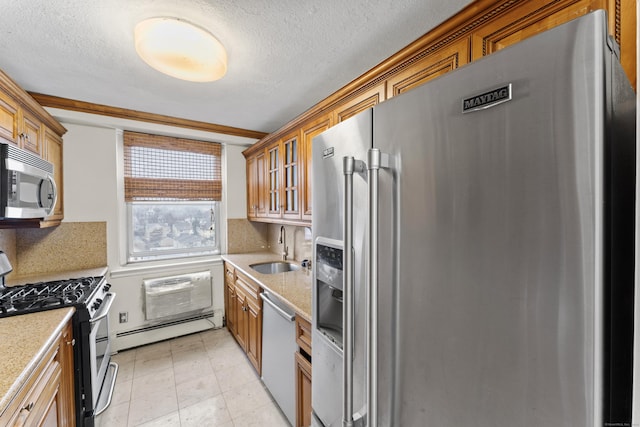 kitchen with sink, a textured ceiling, appliances with stainless steel finishes, a baseboard radiator, and a wall unit AC