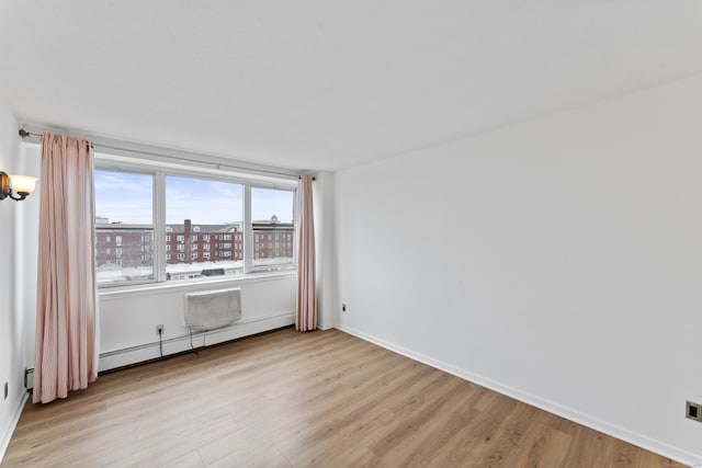 spare room featuring light hardwood / wood-style flooring and a baseboard heating unit