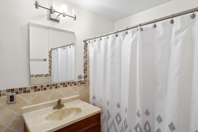 bathroom with vanity, a textured ceiling, walk in shower, and tile walls