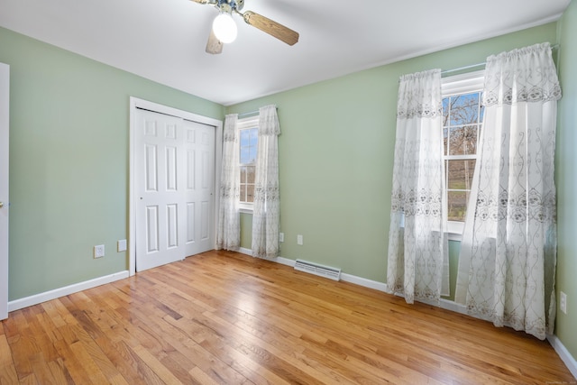 unfurnished bedroom featuring ceiling fan, a closet, and light wood-type flooring