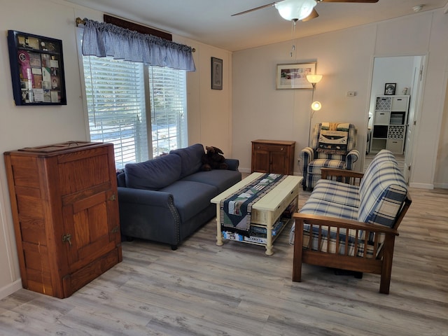 living area featuring vaulted ceiling, light wood finished floors, and ceiling fan