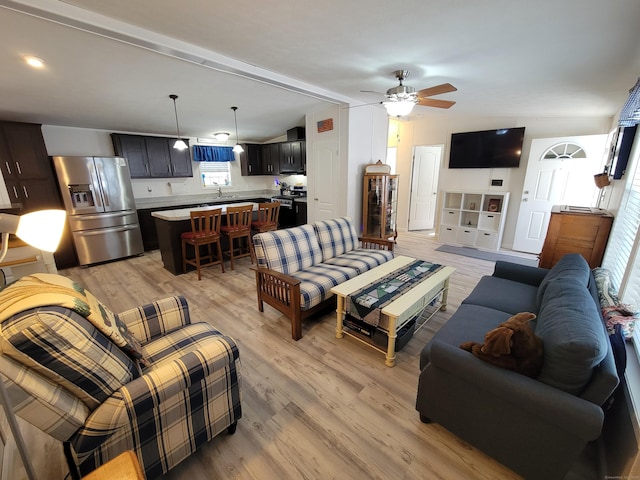 living room with lofted ceiling, light wood-type flooring, and ceiling fan