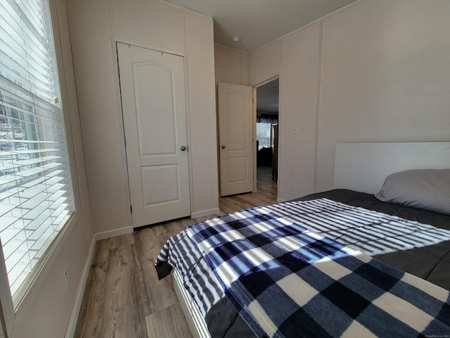 bedroom featuring light wood-style floors and baseboards