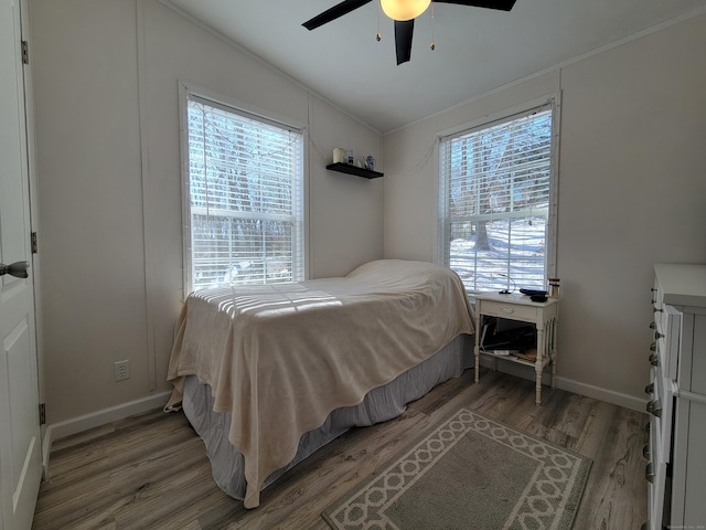 bedroom featuring lofted ceiling, ceiling fan, baseboards, and wood finished floors