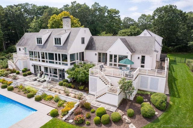 back of house with a pool side deck, a yard, and a patio