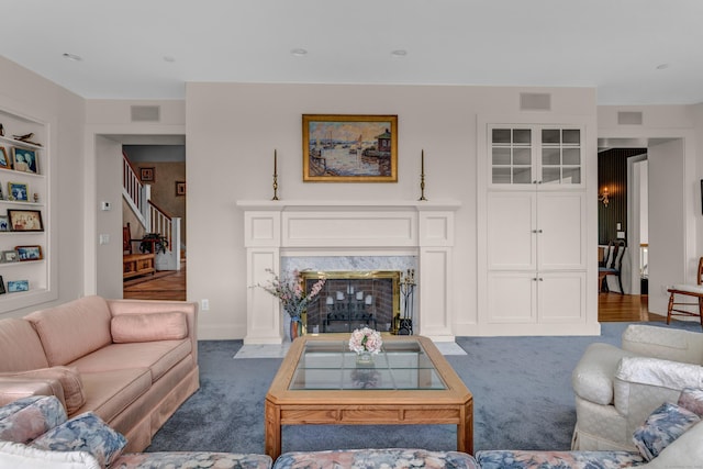 living room featuring a fireplace and dark colored carpet