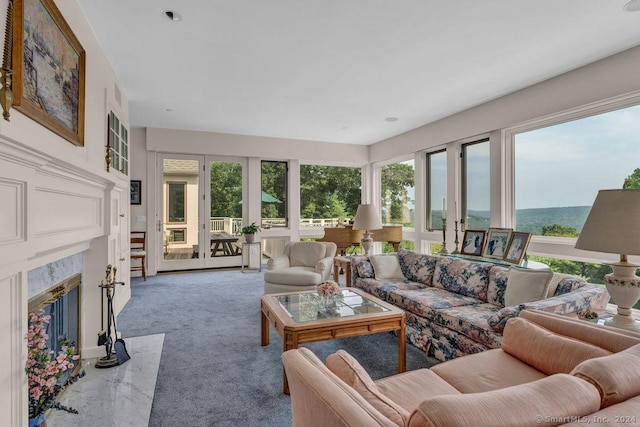 living room with carpet floors, a wealth of natural light, and a premium fireplace