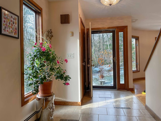 tiled entryway featuring baseboard heating and a wealth of natural light