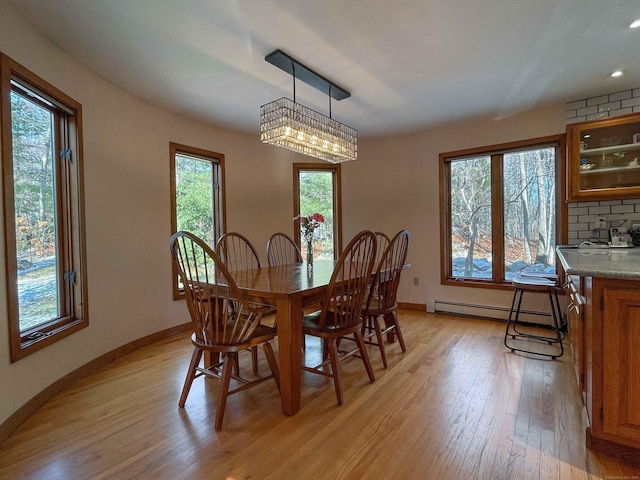 dining space with light hardwood / wood-style flooring and a baseboard radiator