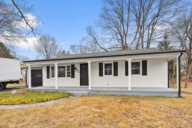 view of front of property with covered porch, a front yard, and a garage