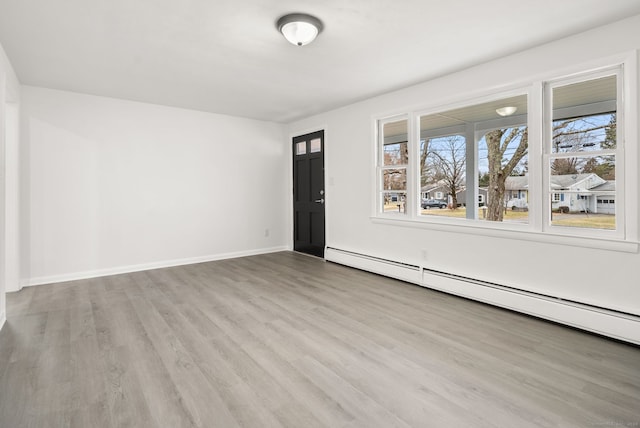 interior space featuring light wood-type flooring and a baseboard heating unit