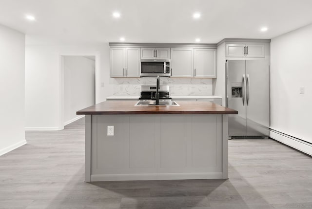 kitchen with wooden counters, gray cabinetry, stainless steel appliances, sink, and light hardwood / wood-style flooring