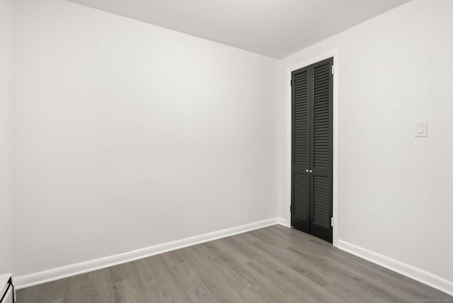 unfurnished bedroom featuring a closet and hardwood / wood-style floors