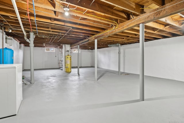 basement featuring gas water heater and washer / dryer