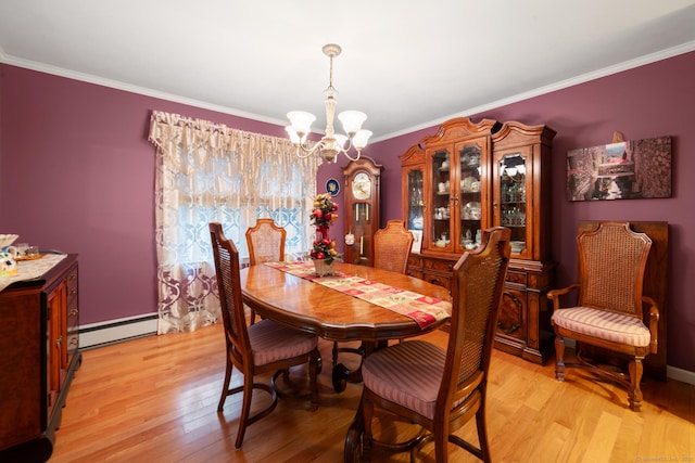 dining area with crown molding, a baseboard heating unit, an inviting chandelier, and light hardwood / wood-style floors