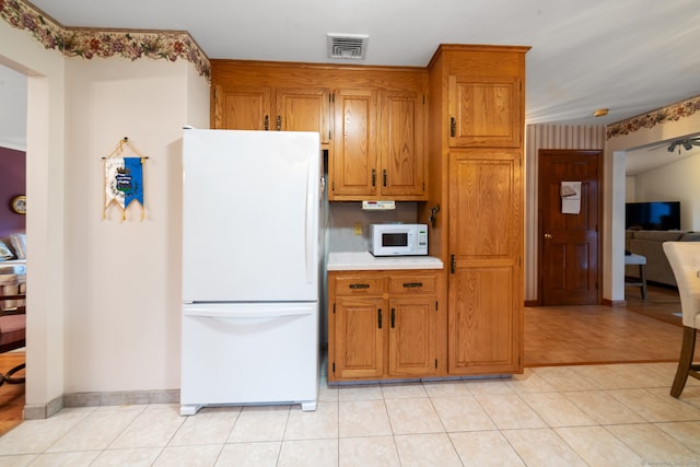 kitchen with light tile patterned flooring and white appliances