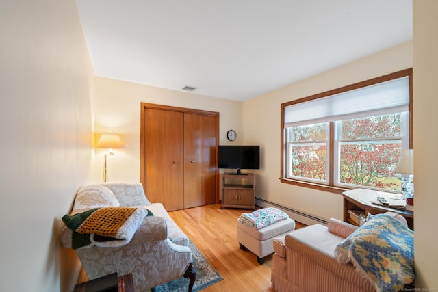 living room featuring baseboard heating and light hardwood / wood-style floors