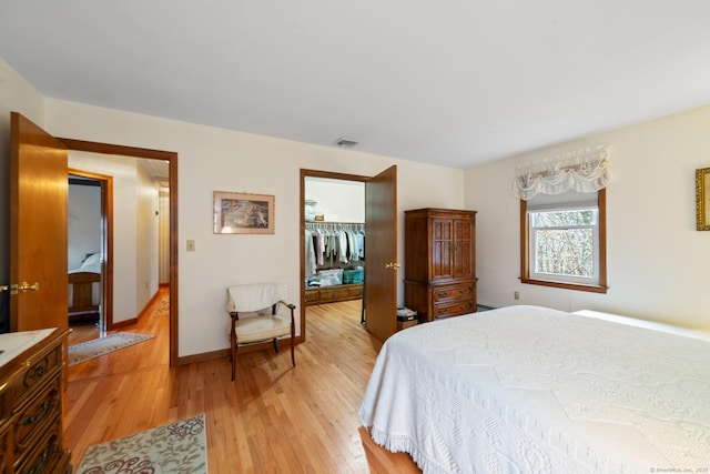 bedroom featuring a closet, a walk in closet, and light hardwood / wood-style floors