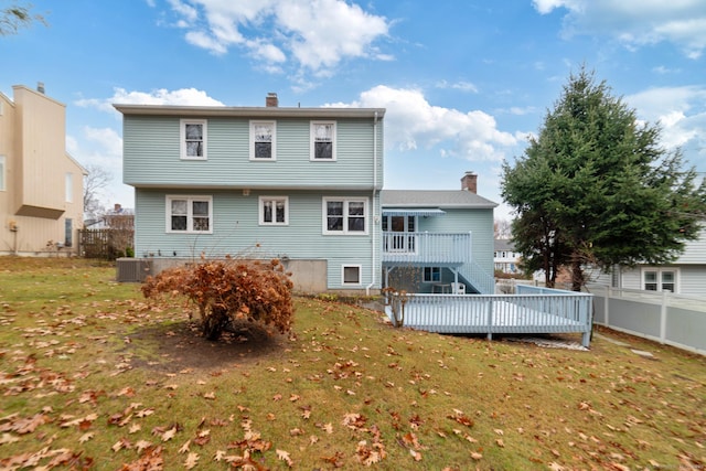 rear view of house with a deck, cooling unit, and a yard