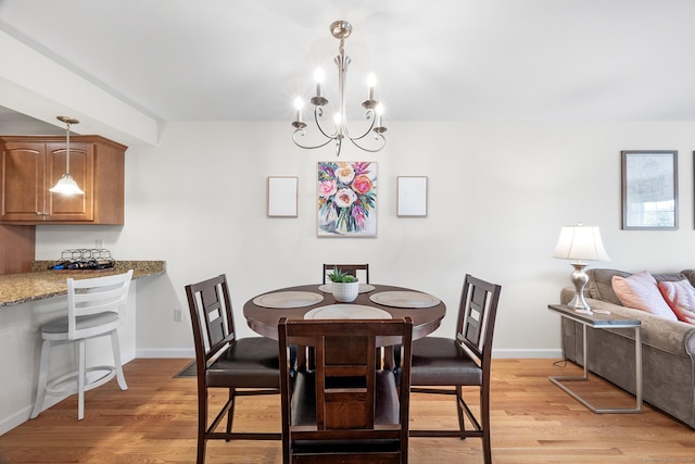 dining space with a chandelier and light hardwood / wood-style flooring