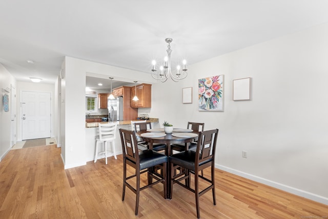 dining area featuring light hardwood / wood-style flooring and an inviting chandelier