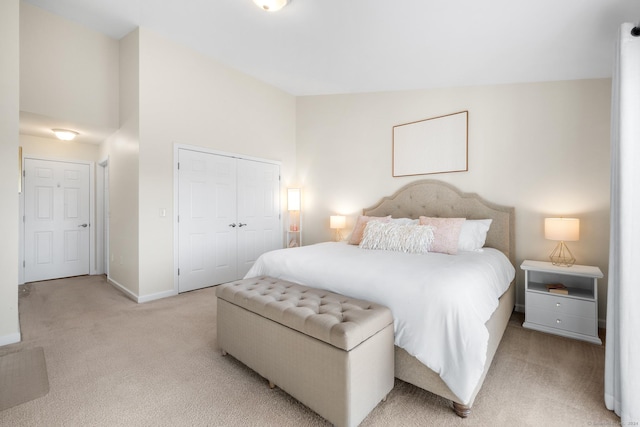 carpeted bedroom with a closet and high vaulted ceiling