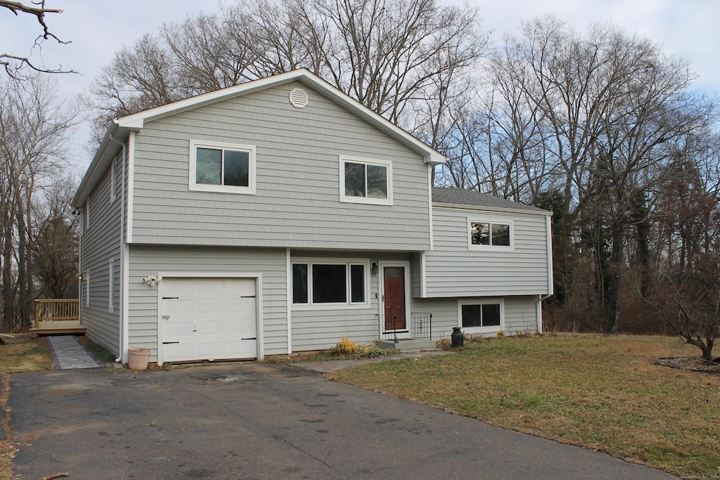 tri-level home featuring a garage and a front yard