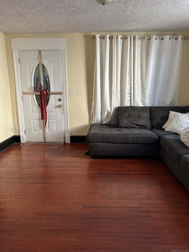 unfurnished living room featuring a textured ceiling and dark wood-type flooring