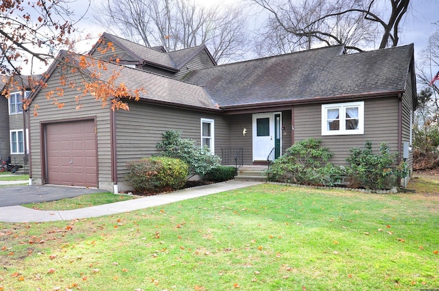 view of front of home with a front yard and a garage