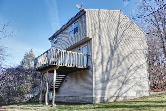 view of property exterior featuring a wooden deck and a yard