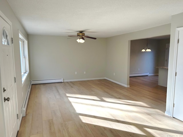 unfurnished room featuring baseboard heating, light hardwood / wood-style flooring, and ceiling fan with notable chandelier