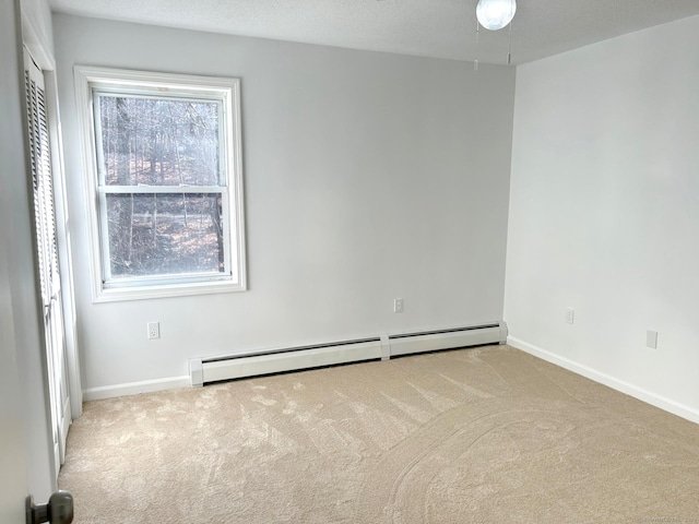 unfurnished room featuring light carpet, a textured ceiling, and a baseboard heating unit