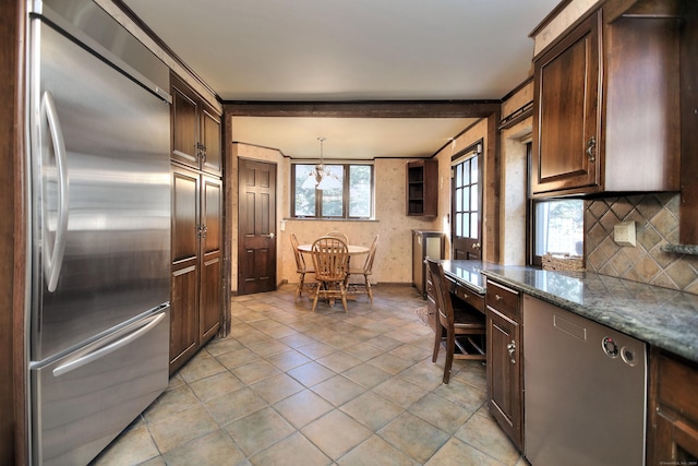 kitchen with stainless steel built in fridge, light stone countertops, hanging light fixtures, and dark brown cabinetry