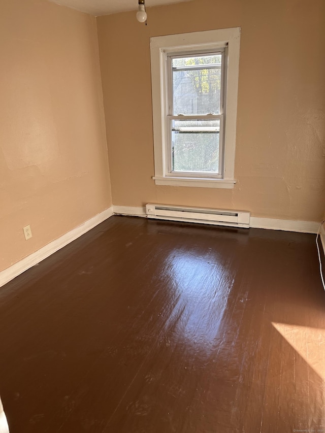 unfurnished room featuring a baseboard radiator and hardwood / wood-style flooring