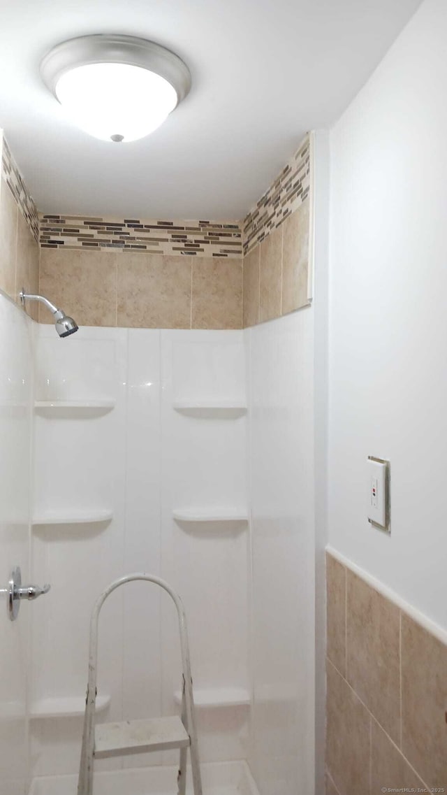 bathroom featuring a shower and tile walls