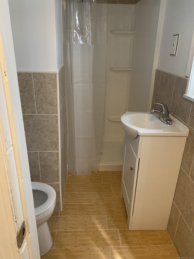 bathroom featuring walk in shower and tile walls