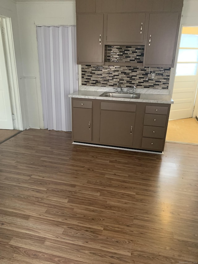 kitchen with gray cabinets, decorative backsplash, sink, and dark hardwood / wood-style floors