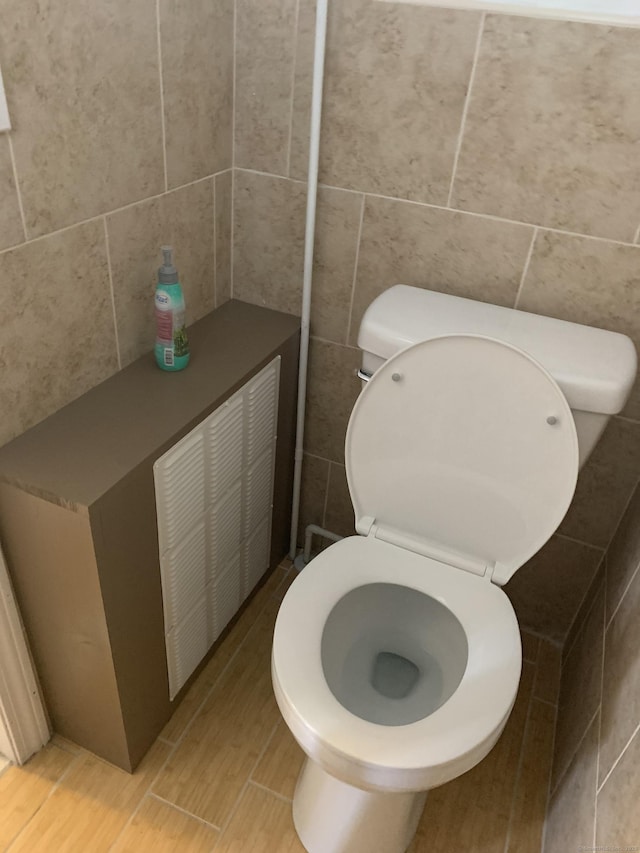 bathroom with tile walls and toilet