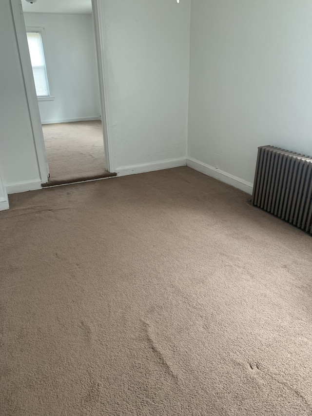 carpeted empty room featuring radiator