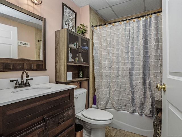 full bathroom with a paneled ceiling, shower / tub combo with curtain, vanity, and toilet