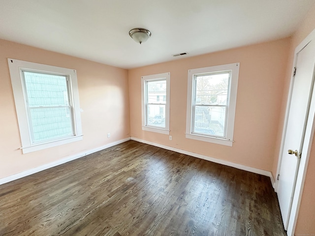 unfurnished room with dark wood-type flooring